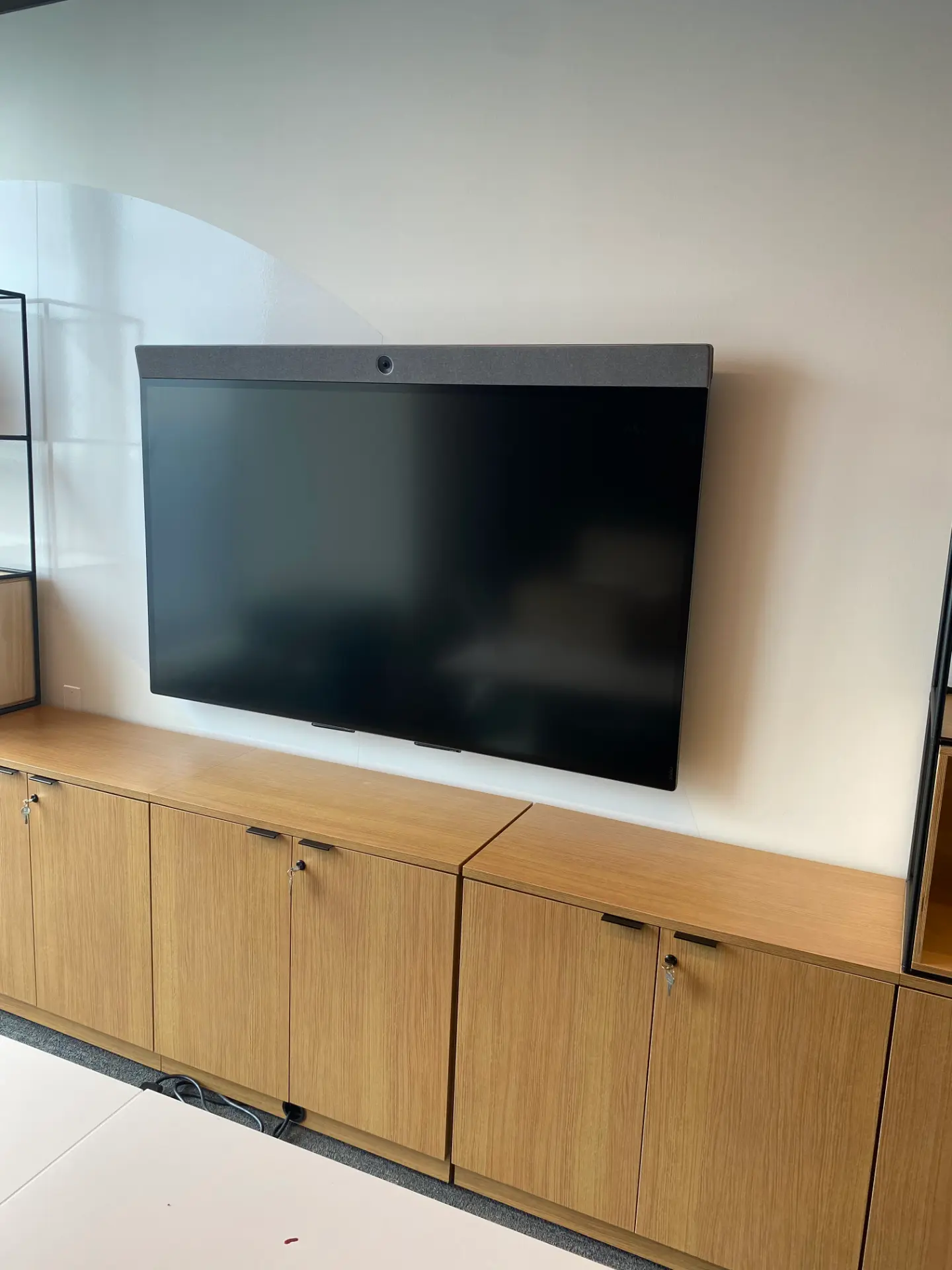 A television mounted by KeyMVP above a wood media console